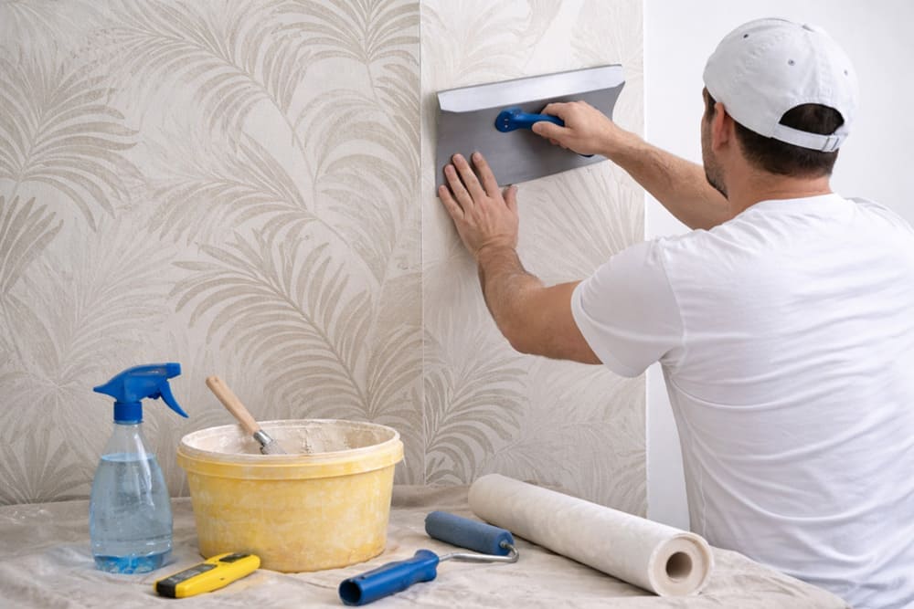 Instalación de papel pintado paso a paso utilizando una espátula alisadora sobre la pared